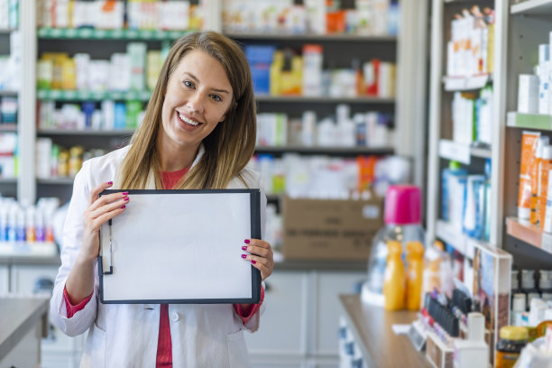 美丽微笑的女药剂师，拿着带空纸的剪贴板。图片下载