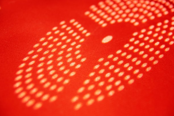 太阳光投射出圆盘状的圆形阴影。抽象的阴影点在红色背景上。图片下载