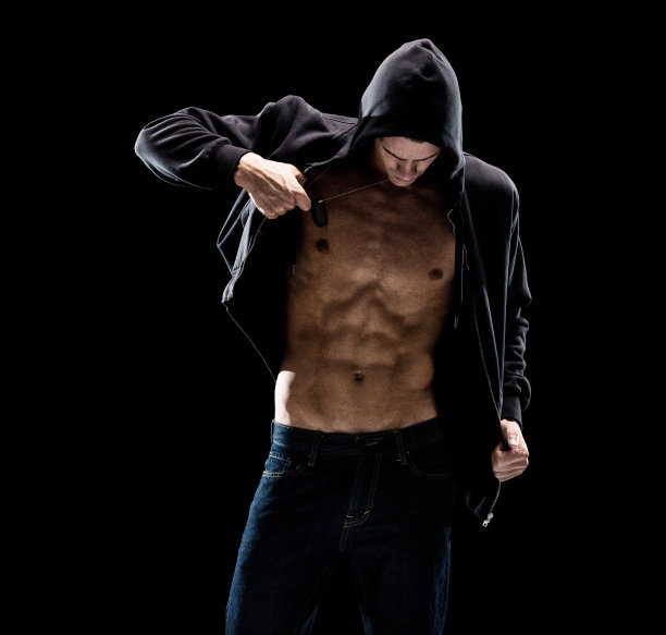 美丽性感的男人穿着连帽衬衫/夹克和慢慢脱衣服图片下载