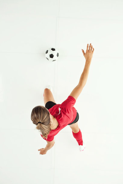 全长/直接俯瞰20-29岁的成年人美丽的棕色头发/长发高加索女性/年轻女子足球运动员/运动员/女子足球踢在白色背景穿足球制服和踢足球-运动图片下载