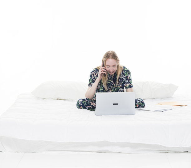 迷人的女性在她的床上使用技术，如笔记本电脑图片下载