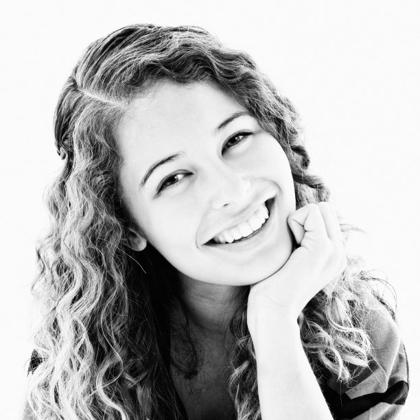 可爱的卷发少年微笑在黑白肖像图片下载