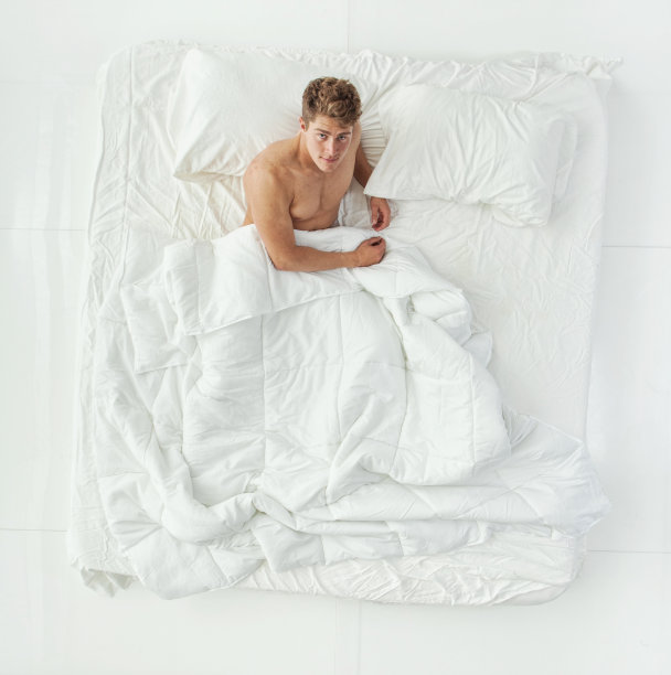 全长/一人/直接上方视图/正面视图/看相机/看20-29岁的成年人英俊的人/苗条的棕色头发/短发白人男性/年轻男子躺在背部/躺下/午睡/凉爽的态度图片下载