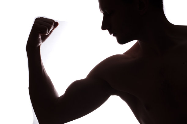 年轻的肌肉健美者在白色背景上展示他的二头肌图片下载