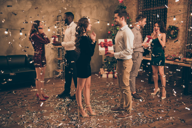 全尺寸的侧面照片英俊的男人给爱人的包裹在圣诞派对圣诞夜在房子里与五彩纸屑掉在地板上室内图片下载