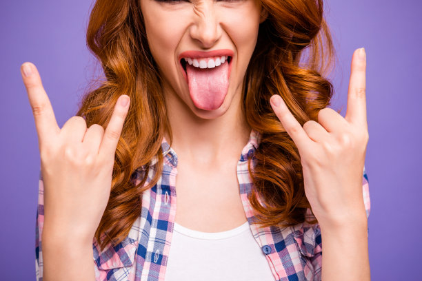 短发照片姜女士在摇滚音乐会显示角伸出舌头嘴穿休闲格子衬衫孤立的紫色背景图片下载