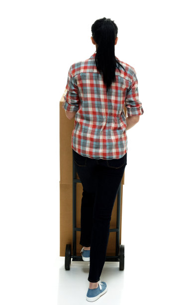 全长/后视图/ 18-19岁的成年人美丽的黑发/长发/马尾辫高加索女性/年轻妇女送货人/手工工人走在白色背景谁是微笑/快乐/愉快/凉爽的态度图片下载