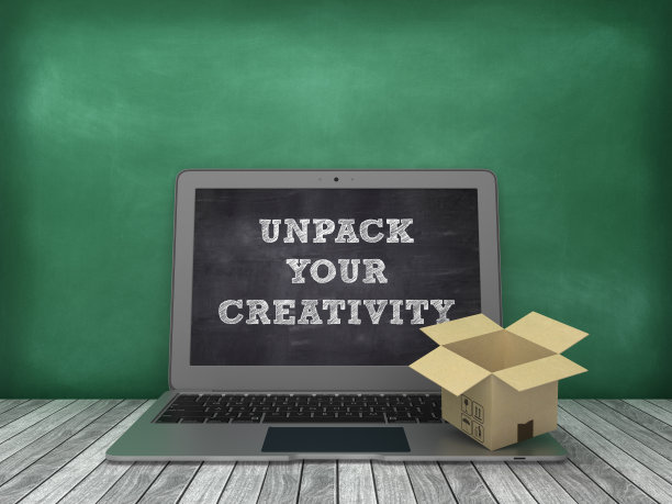 笔记本电脑与打开你的创意短语和纸板盒在黑板背景- 3D渲染图片下载