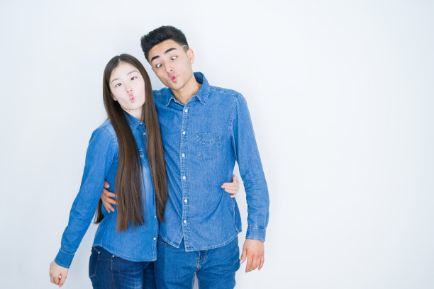 美丽的年轻亚洲夫妇在白色孤立的背景，使鱼的脸与嘴唇，疯狂和滑稽的手势。有趣的表情。图片下载