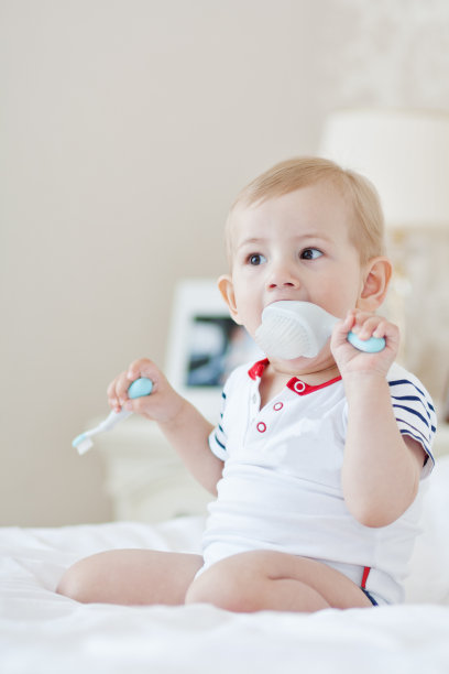 小男孩在床上刷牙，灯光背景，特写，肖像。健康生活方式的概念图片下载