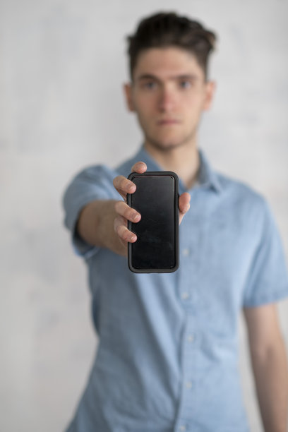 一个年轻人拿着手机的肖像图片下载