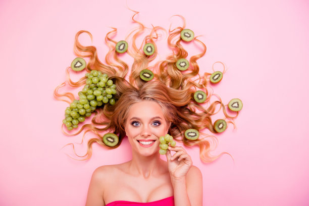 近看上面的高角度的照片美丽的她她的夫人躺下完整的猕猴桃长卷发健康的生活方式沙龙程序额外的服务美味美味孤立的粉色背景图片下载