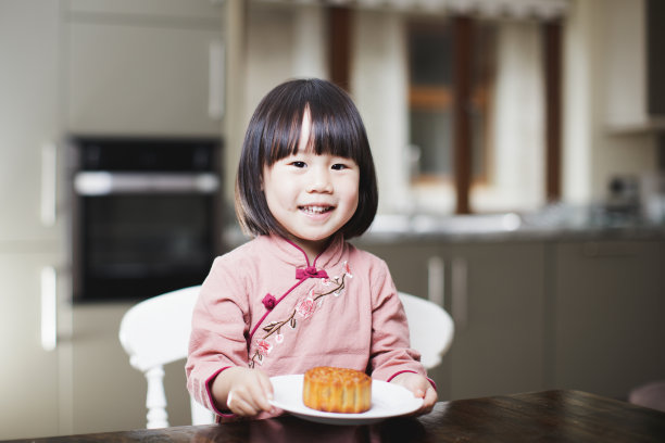 小女孩吃月饼，庆祝中秋节图片下载