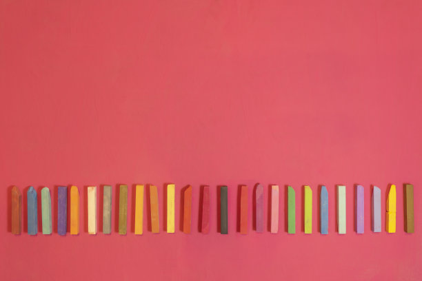 用蜡笔在红色背景上着色。图片下载