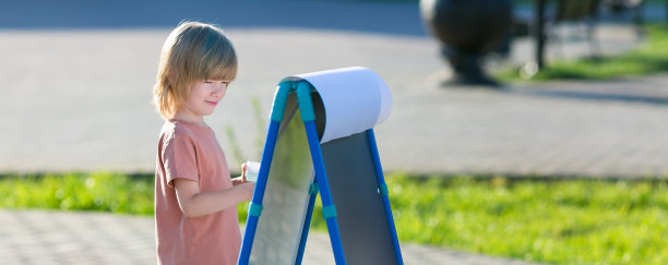 一个男孩在街上画画。图片下载