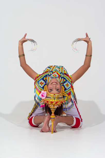 美丽的女子穿着泰国南方民族舞蹈服装，由彩色的珠子制成，她的头上戴着头饰，在背景上显示出拱桥的姿势图片下载