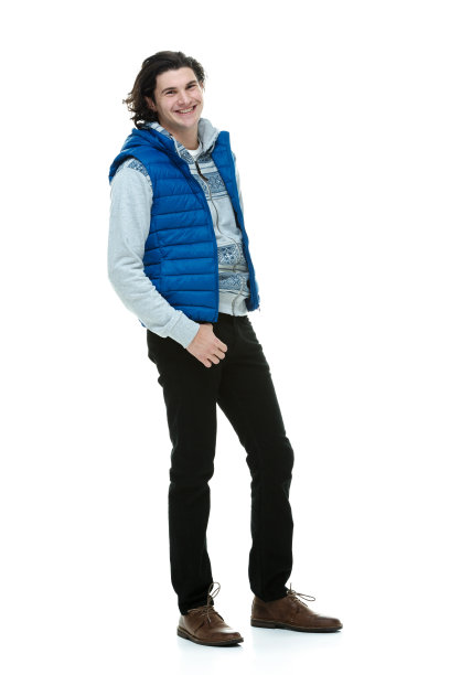 全身/一人/一人20-29岁英俊的人/长发白人男性站在白色背景前，穿着背心/连帽夹克/衬衫/运动衫/牛仔裤谁是微笑/快乐/愉快图片下载