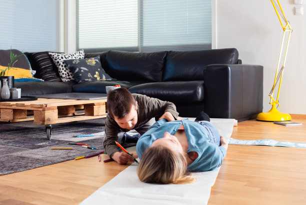 年轻的母亲和一年级的儿子在家里一起画画图片下载