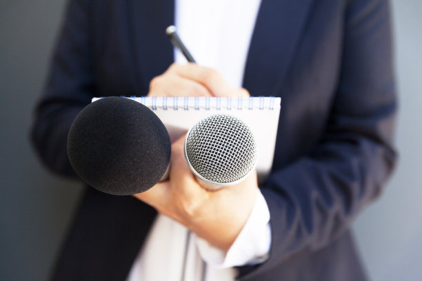 女记者参加新闻发布会或媒体活动，写笔记，拿麦克风图片下载