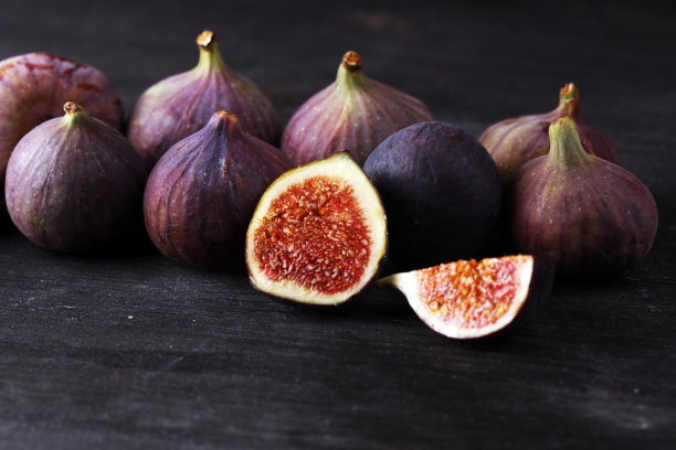 新鲜的无花果。食物的照片。整个和切片无花果在美丽的乡村背景。图片下载