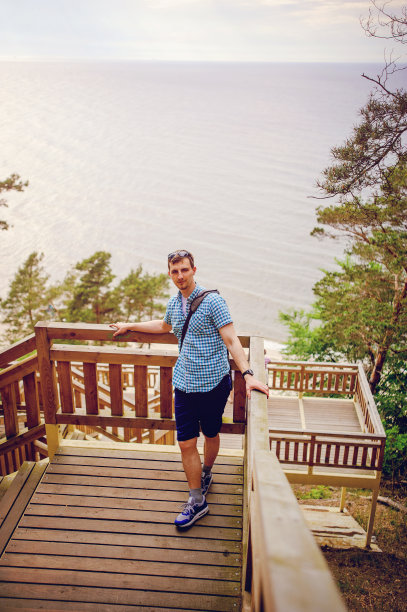 坐在公园木楼梯上微笑的男人图片下载