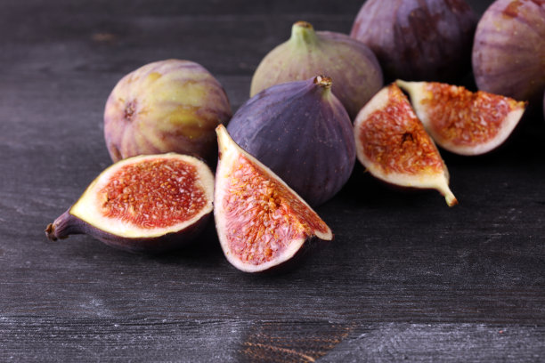 新鲜的无花果。食物的照片。整个和切片无花果在美丽的乡村背景。图片下载