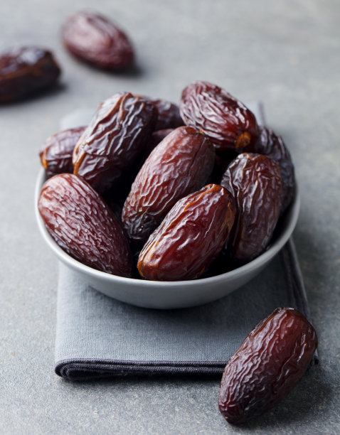 碗里的新鲜medjool枣。灰色背景。关闭了。图片下载