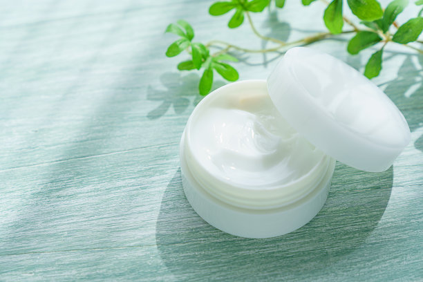 木制背景上的白色美容霜图片下载