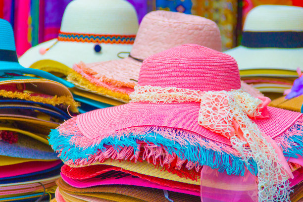 女式的夏季草帽颜色柔和，色彩丰富。暑假的帽子时尚和一张美女照片。——图片图片下载