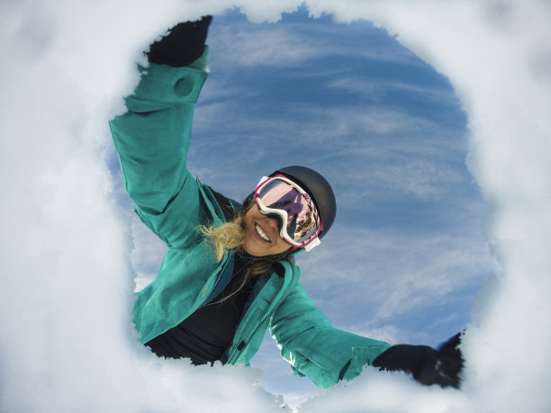 从智利的一个雪洞中看到一个女人微笑着穿着滑雪/雪衣服图片下载