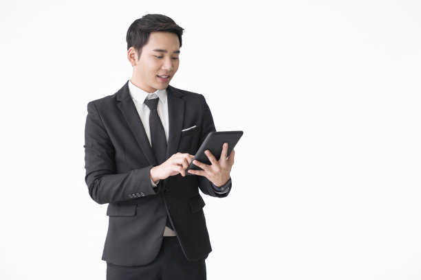 孤立的白人商人分析股市和使用智能手机，数字平板电脑和笔记本电脑在办公室图片下载