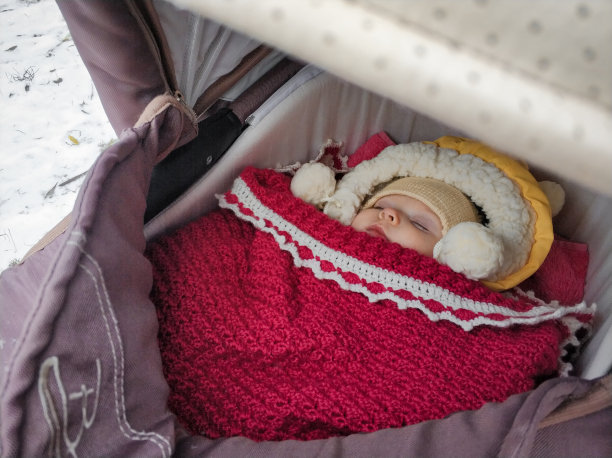 冬天，小女孩睡在婴儿车里图片下载