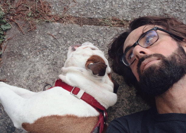 一名男子和他的英国斗牛犬一起在户外休息图片下载