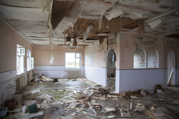 废弃的空房间，被毁的建筑，有破窗户的房间，在废弃的废弃房子里有两扇窗户的房间。内部废弃建筑图片下载