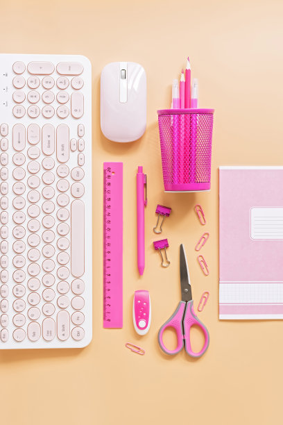 女性化的工作空间，用电脑和文具，以粉色为柔和的背景。平铺办公室桌子书桌框架。图片下载