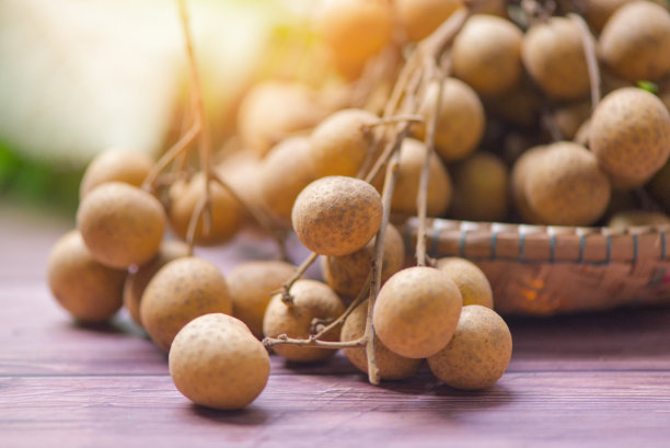 篮子上龙眼-龙眼果在木背景和阳光在夏天图片下载