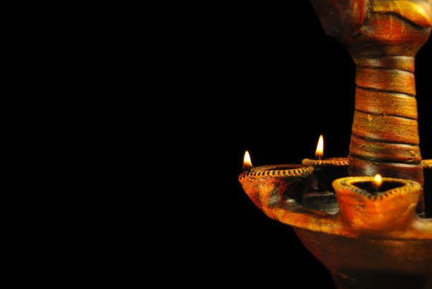 快乐的排灯节，水平照片的印度节日排灯节Deepawali庆祝，点燃mitti或赤陶土diya与放置在一个塔在黑色的背景图片下载
