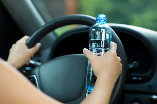 女孩开着车，拿着一个水瓶图片下载