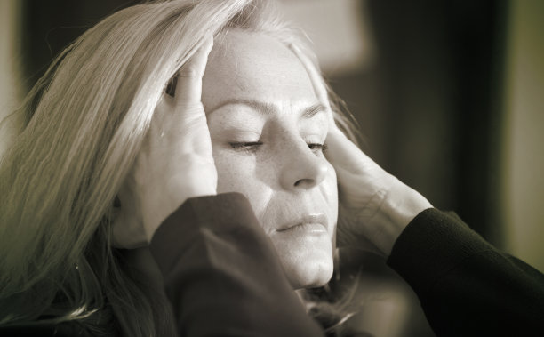 一个悲伤的女人坐在客厅的沙发上。黑白照片图片下载