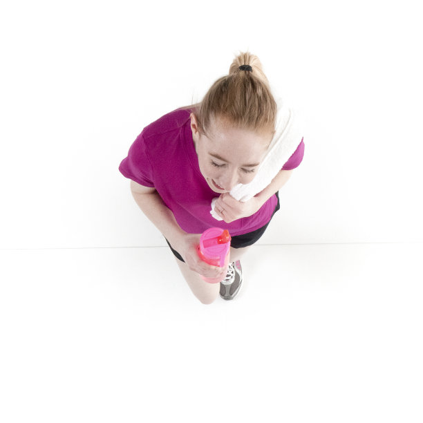 正上方的视图20-29岁的成年美丽的白人女性/年轻女性跑步/锻炼在白色的背景和拿着或穿着毛巾和拿着水瓶图片下载