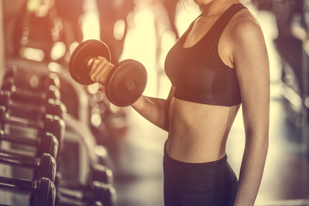 健美运动员在健身房用哑铃锻炼。图片下载