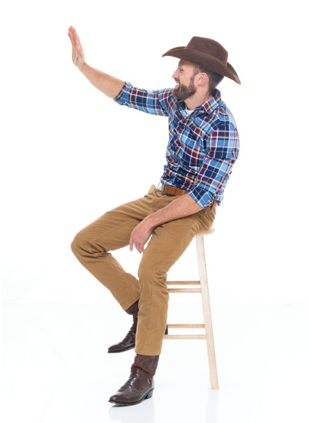 一人独/一人/全身/侧视图/侧面视图30-39岁的成年英俊的人白人青年男子/男牛仔坐在/休息在白色背景下穿着牛仔靴/牛仔帽/帽子和问候图片下载