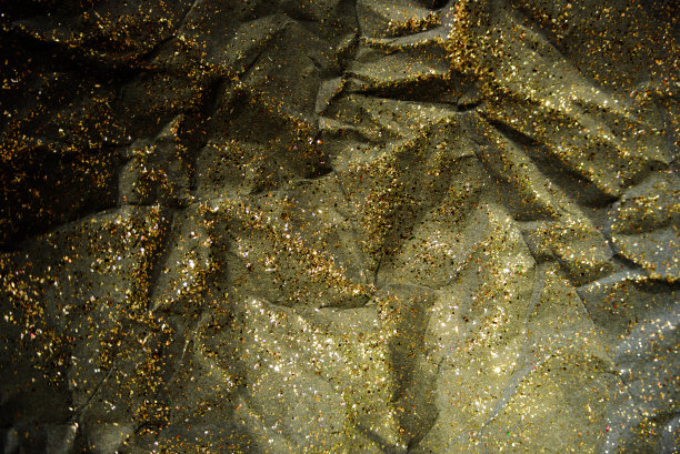 皱巴巴的黑纸和金色的闪光图片下载