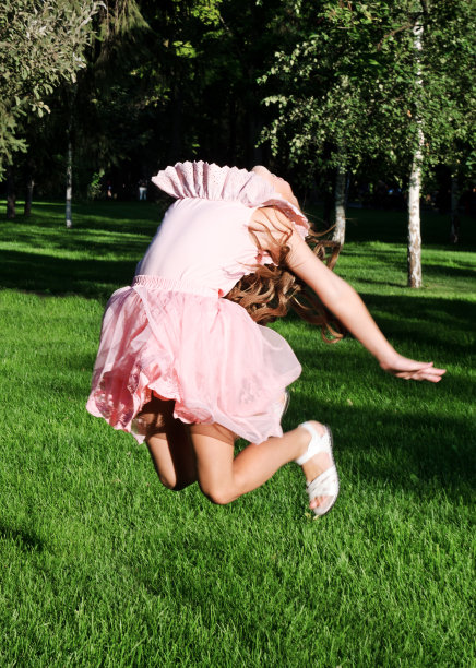 可爱快乐的小女孩在夏天的公园里蹦蹦跳跳图片下载