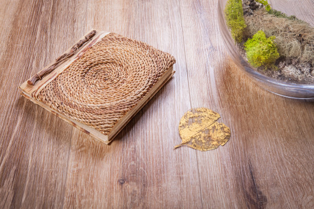 木地板上放着一本旧书和金色的叶子图片下载