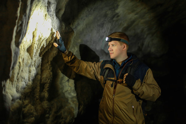 在喀斯特洞穴里，人们触摸着一堵墙图片下载