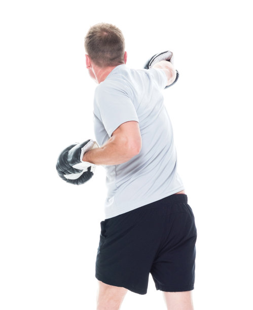 1人/一人/后视图/腰部以上20-29岁英俊的人棕色头发/短发白人男性/年轻男子运动员/运动员站在白人背景和拳击/展示拳头/运动图片下载