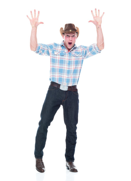 正面图/一人/全身20-29岁的白人青年/男性牛仔站在白色背景前，穿着牛仔靴/牛仔帽/帽子/伐木工衬衫，兴奋/快乐/微笑图片下载