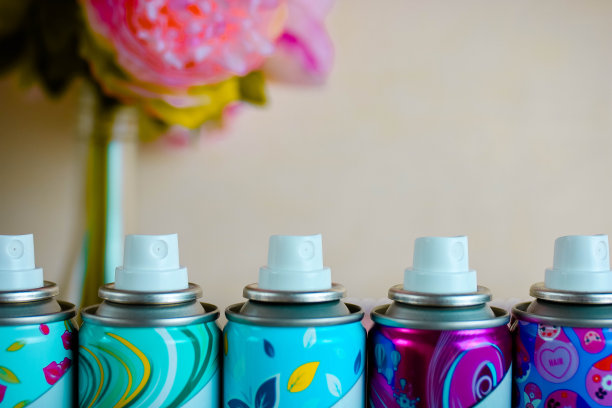 五个除臭剂喷嘴闭合。五只彩色喷雾瓶，米色模糊背景。图片下载