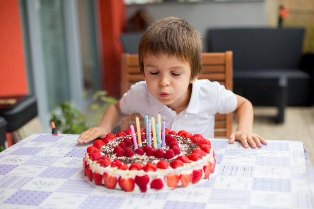 学龄前儿童，在他的生日蛋糕上吹蜡烛图片下载